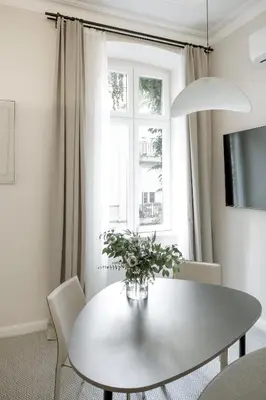 a white dining room with a white table and a window at Design Suite in Prime Location Superstring Home in Belgrade