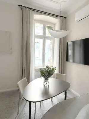 a white dining room with a table and chairs at Design Suite in Prime Location Superstring Home in Belgrade