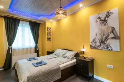 a bedroom with a bed and a painting on the wall at The Belfort Townhomes - Lux Salon in Belgrade