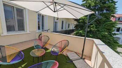 a group of chairs and an umbrella on a patio at The Belfort Townhomes - Lux Salon in Belgrade