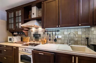 a kitchen with wooden cabinets and a stove top oven at The Belfort Townhomes - Lux Salon in Belgrade