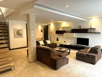 a living room with two couches and a television at Triplex with garden and parking in Belgrade