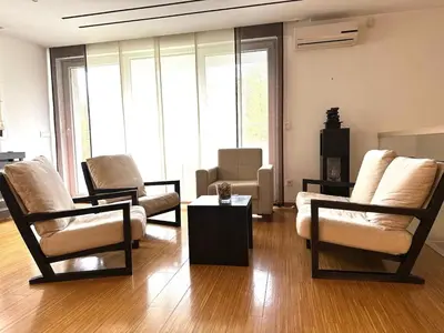 a living room with two chairs and a table at Triplex with garden and parking in Belgrade