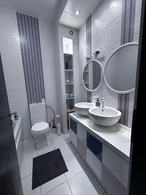 a bathroom with two sinks and a toilet and mirrors at Triplex with garden and parking in Belgrade