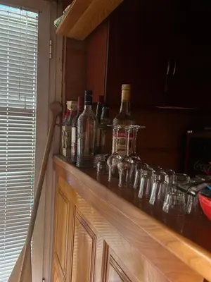a counter with alcohol bottles and glasses on it at Splav na Savi KALIVARIJA in Belgrade
