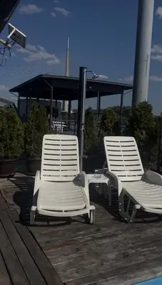 two white chairs sitting on a deck next to a pool at Splav na Savi KALIVARIJA in Belgrade