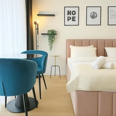 a bedroom with a bed and a table and chairs at Queen's Park Residence Apartments in Belgrade