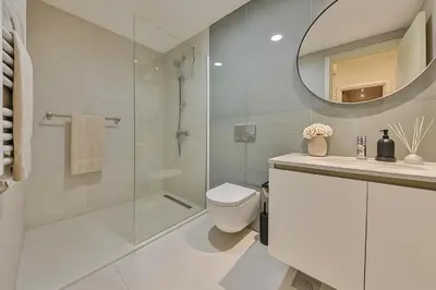 a bathroom with a shower and a toilet and a mirror at Queen's Park Residence Apartments in Belgrade