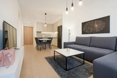 a living room with a couch and a table at Queen's Park Residence Apartments in Belgrade
