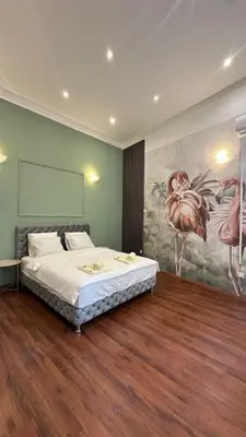 a bedroom with a bed and a painting on the wall at Eight Apartment in Belgrade