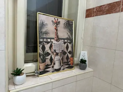 a picture of a giraffe sitting on a window sill at Eight Apartment in Belgrade