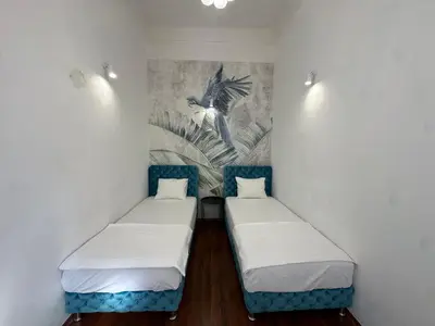 two beds in a room with a painting on the wall at Eight Apartment in Belgrade