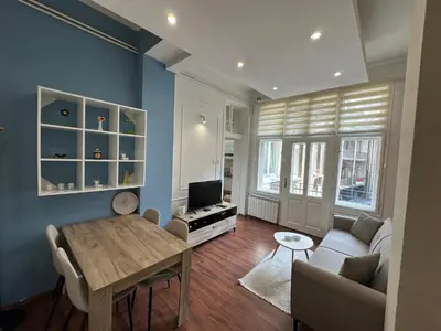 a living room with a table and a couch and a tv at Eight Apartment in Belgrade