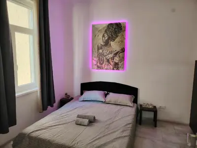 a bedroom with a bed with a picture on the wall at Nefertiti Apartment in Belgrade