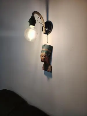 a head hanging on a wall next to a light at Nefertiti Apartment in Belgrade