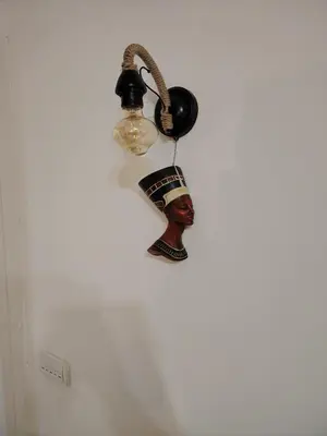 a wall mounted lamp with a black chief on it at Nefertiti Apartment in Belgrade