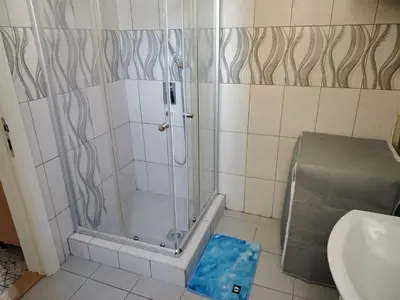 a shower with a glass door in a bathroom at Nefertiti Apartment in Belgrade