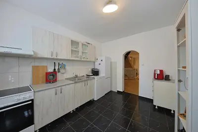 a kitchen with white cabinets and a black tile floor at Avalavanda Cherry Hill in Vlasi