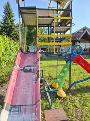 a playground with a slide and a slideintend at Nasa kuca in Gročanska Ada