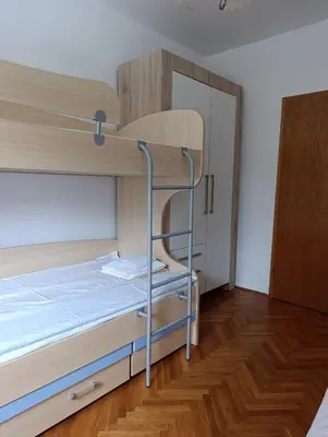 a bunk bed with a ladder in a room at SREMICA - Guest House in Pećinci