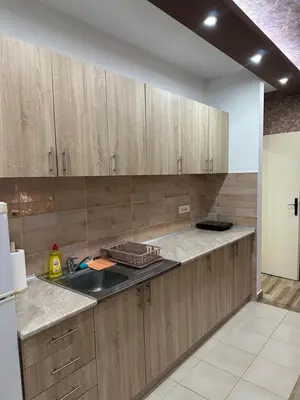 a kitchen with wooden cabinets and a sink at DP Lux apartman Obrenovac,sa parkingom in Obrenovac