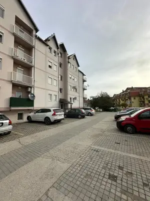 a parking lot with cars parked in front of buildings at DP Lux apartman Obrenovac,sa parkingom in Obrenovac