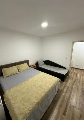 a bedroom with a bed and a mirror on the wall at DP Lux apartman Obrenovac,sa parkingom in Obrenovac
