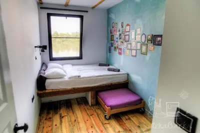 a small bed in a room with a window at ArkaBarka 2- Floating Dream Rooms and Apartments in Belgrade