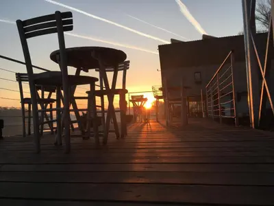 a group of chairs sitting on a dock at sunset at ArkaBarka 2- Floating Dream Rooms and Apartments in Belgrade