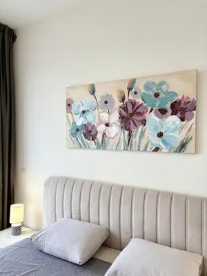 a painting of flowers on a wall above a couch at BW Aqua Waterside Sandy in Belgrade