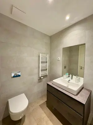 a bathroom with a sink and a toilet and a mirror at BW Aqua Waterside Sandy in Belgrade