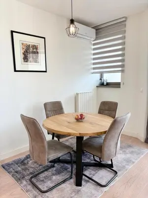 a wooden table and chairs in a living room at BW Aqua Waterside Sandy in Belgrade