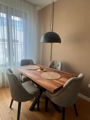 a dining room table with chairs and a black lamp at K-District Apartment Charlie in Belgrade