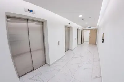 an empty corridor of an office building with glass doors at New York Belgrade Waterfront in Belgrade