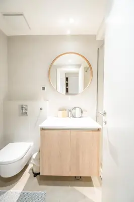 a bathroom with a sink and a toilet and a mirror at New York Belgrade Waterfront in Belgrade