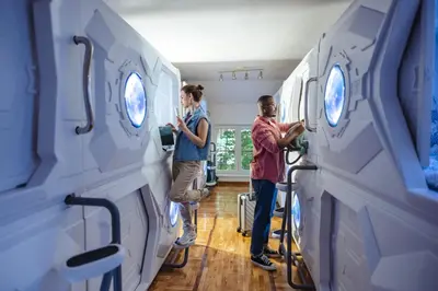 a man and woman in a hospital room looking at cell phones at Belgrade Beocean Capsule Hostel in Belgrade