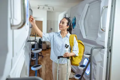 a woman standing in a room looking at a wall at Belgrade Beocean Capsule Hostel in Belgrade