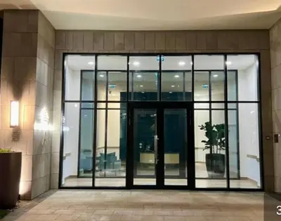 an office building with glass doors and a potted plant at Beograd na vodi - Belgrade Waterfront Luna Apartment in Belgrade