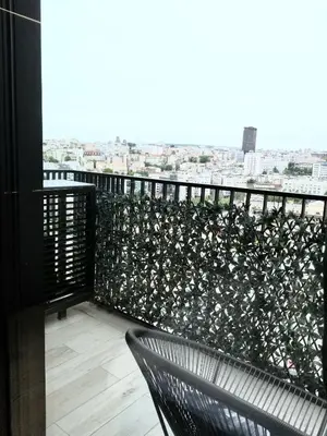 a balcony with two chairs and a fence with flowers at Beograd na vodi - Belgrade Waterfront Luna Apartment in Belgrade