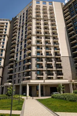 a large apartment building with a sidewalk in front of it at Talija BW in Belgrade