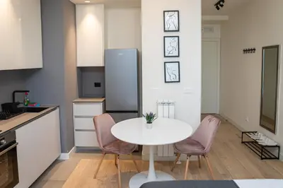 a kitchen with a white table and pink chairs at Talija BW in Belgrade