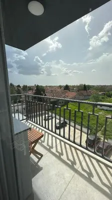 a balcony with a bench and a view of a field at Stan na dan Indjija in Inđija