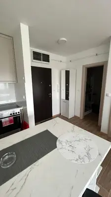 a kitchen with a white counter top in a room at Stan na dan Indjija in Inđija