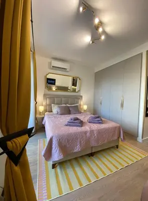 a bedroom with a large bed and a yellow curtain at Belgrade Waterfont, Symphony 1, Studio 307 in Belgrade