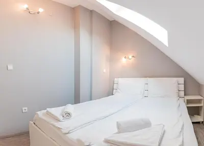 a bedroom with a large bed with white sheets at Long Term Savamala 2BDR for 4 Long Term in Belgrade