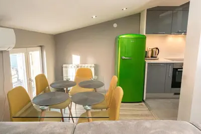 a green refrigerator in a kitchen with tables and chairs at Long Term Savamala 2BDR for 4 Long Term in Belgrade