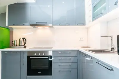 a kitchen with gray cabinets and a black oven at Long Term Savamala 2BDR for 4 Long Term in Belgrade