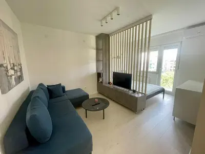 a living room with a blue couch and a table at Apartment LUX 15 Historical Center Belgrade in Belgrade