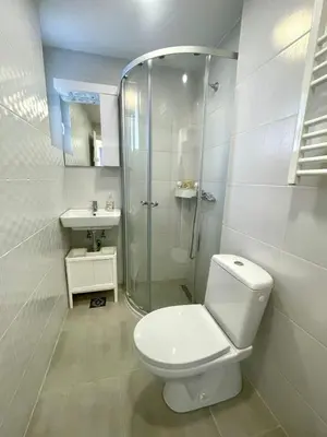 a white bathroom with a toilet and a shower at Apartment LUX 15 Historical Center Belgrade in Belgrade