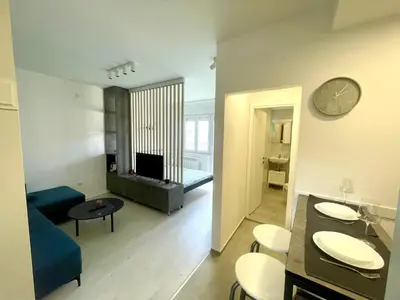 a living room with a blue couch and a living room with a clock at Apartment LUX 15 Historical Center Belgrade in Belgrade